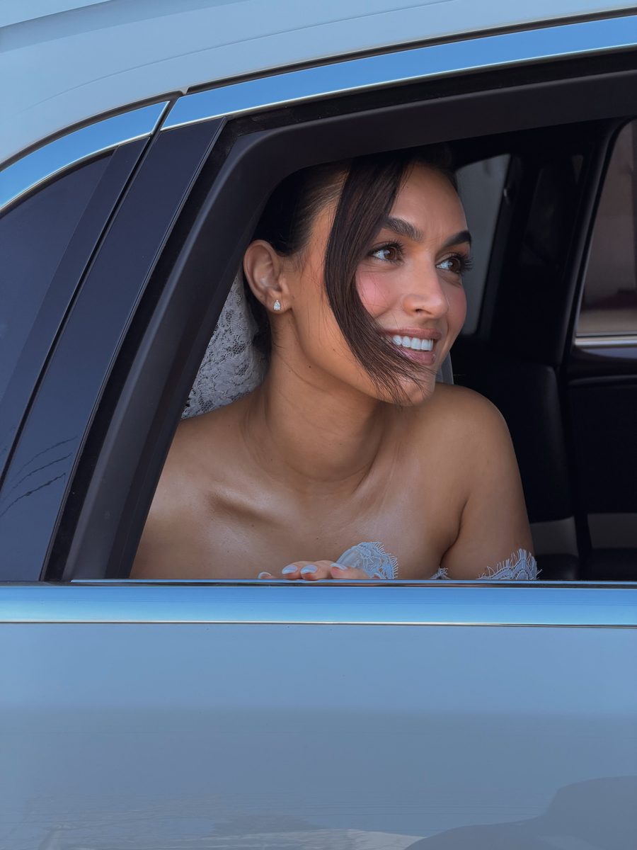 Bride smiling from the car window