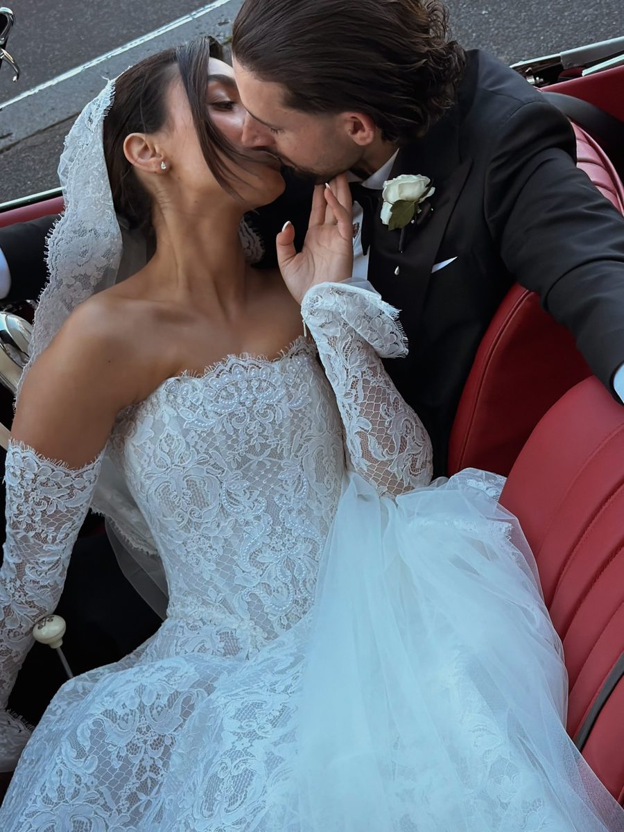Bride and groom kissing in a vintage convertible