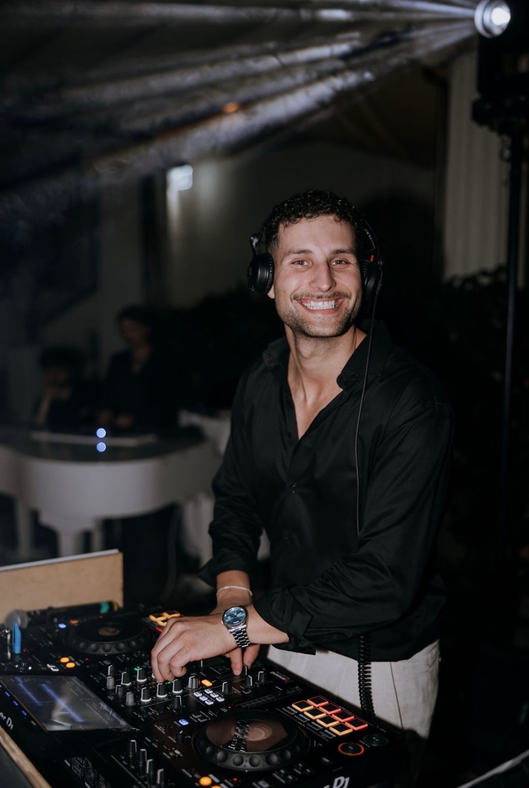 Adrian smiling behind the decks