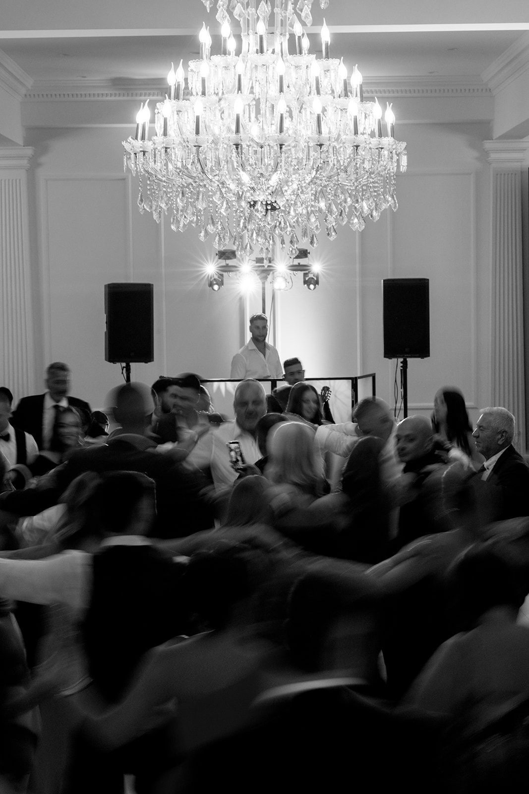 Adrian at the DJ booth under a chandelier