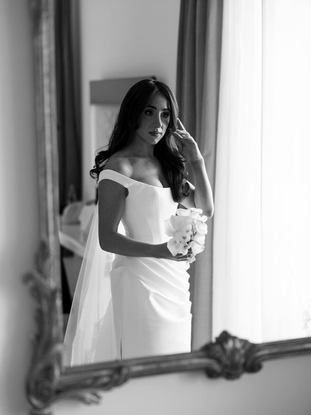 Bride reflected in a gilded mirror, black and white
